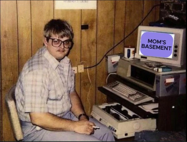 Moms basement image, A man sitting in front his computer smoking a cigarette