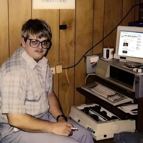 Moms basement image, A man sitting in front his computer smoking a cigarette